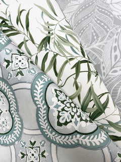 Three overlapping sheets of Willow Grove Wallpaper by York Wallcoverings: one features green leaves, another showcases abstract gray and white designs, and the third displays intricate teal and white floral patterns, all arranged diagonally.