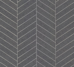 Featuring a dark gray surface with a repeating chevron pattern, the Ronald Redding Atelier Herringbone Wallpaper by York Wallcoverings showcases diagonal white lines meeting at angles to create a striking zigzag effect across the design. The texture appears smooth with a subtly rough finish.