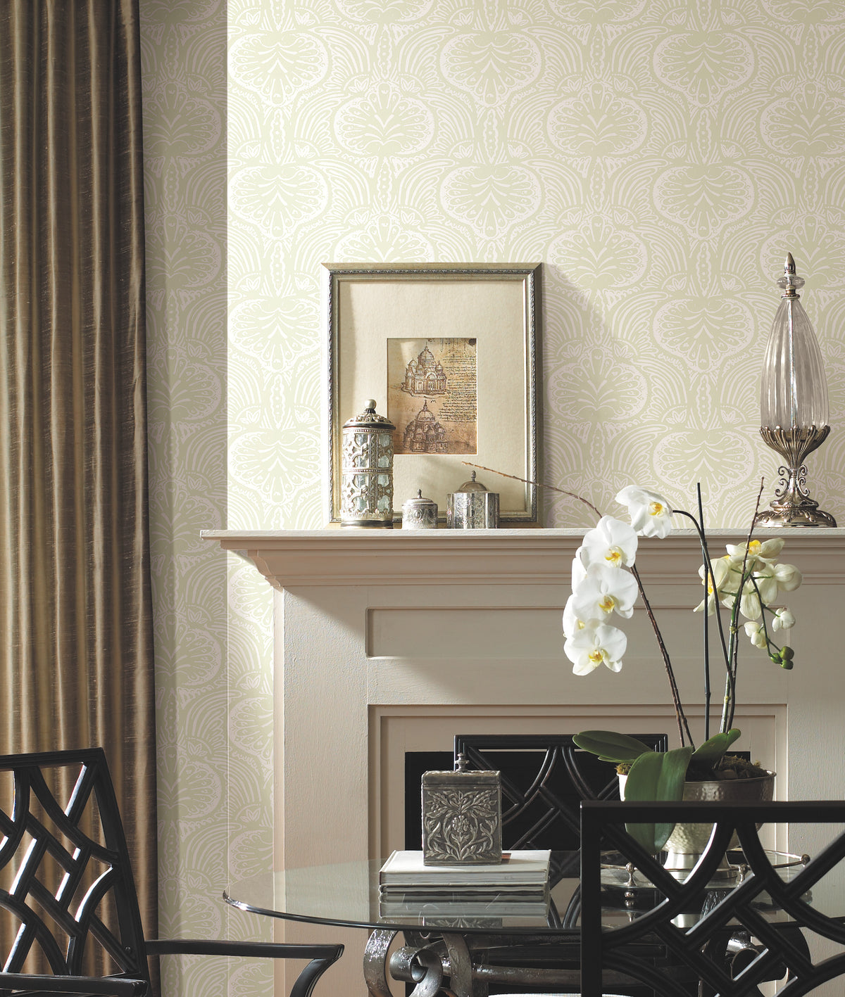 Ronald Redding Lotus Palm Wallpaper by York Wallcoverings with a repeating pale green and white lotus pattern on a wall behind a fireplace mantel.