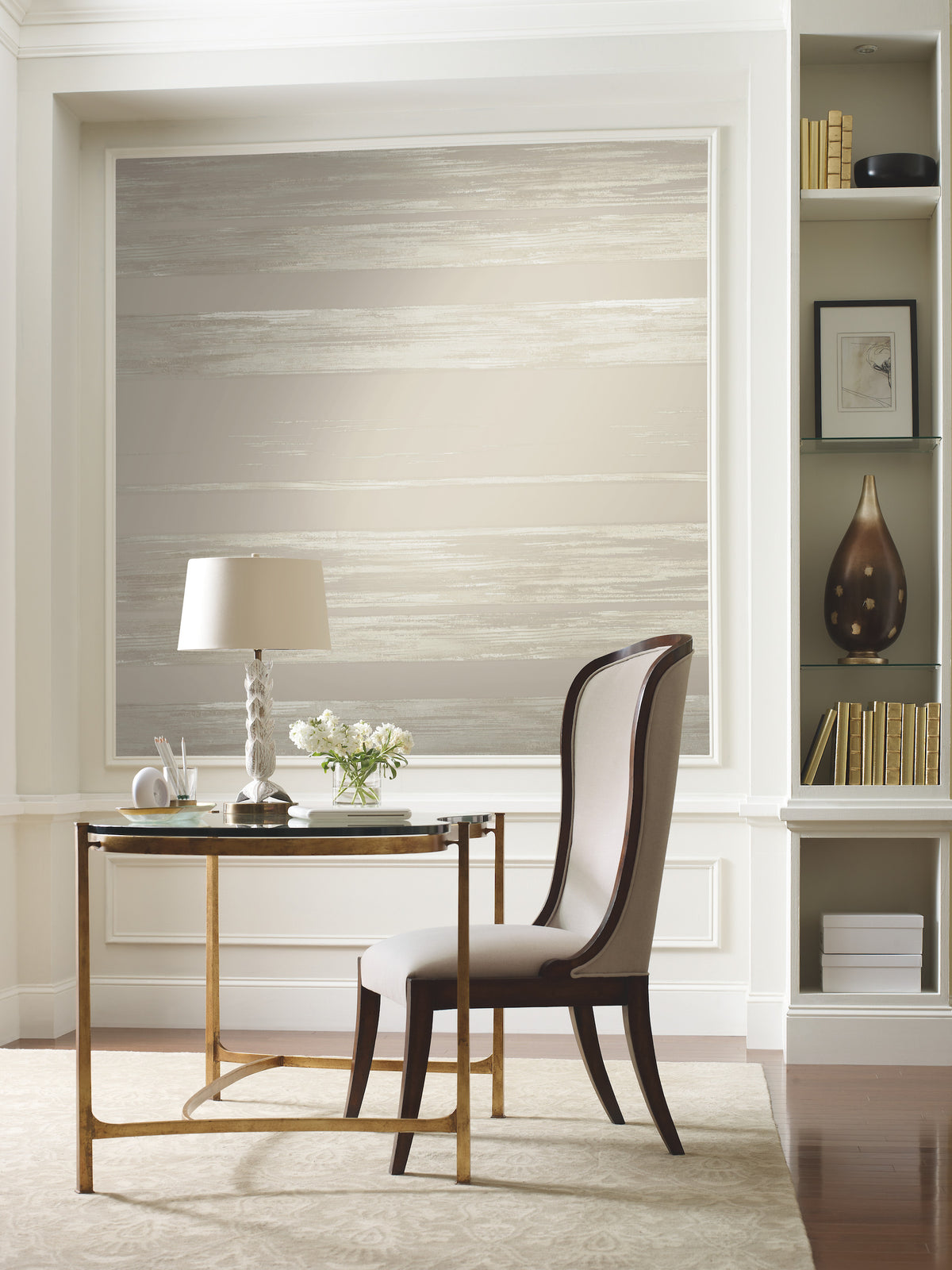 A small desk and upholstered chair sit in front of a wall covered in Ronald Redding Horizontal Dry Brush Wallpaper, featuring a horizontal, dry-brush paint effect in neutral tones.