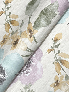 A close-up of the Evelyn Floral Wallpaper by York Wallcoverings, showcasing a floral pattern with yellow, lavender, and blue flowers accented by green leaves on a light, textured background.