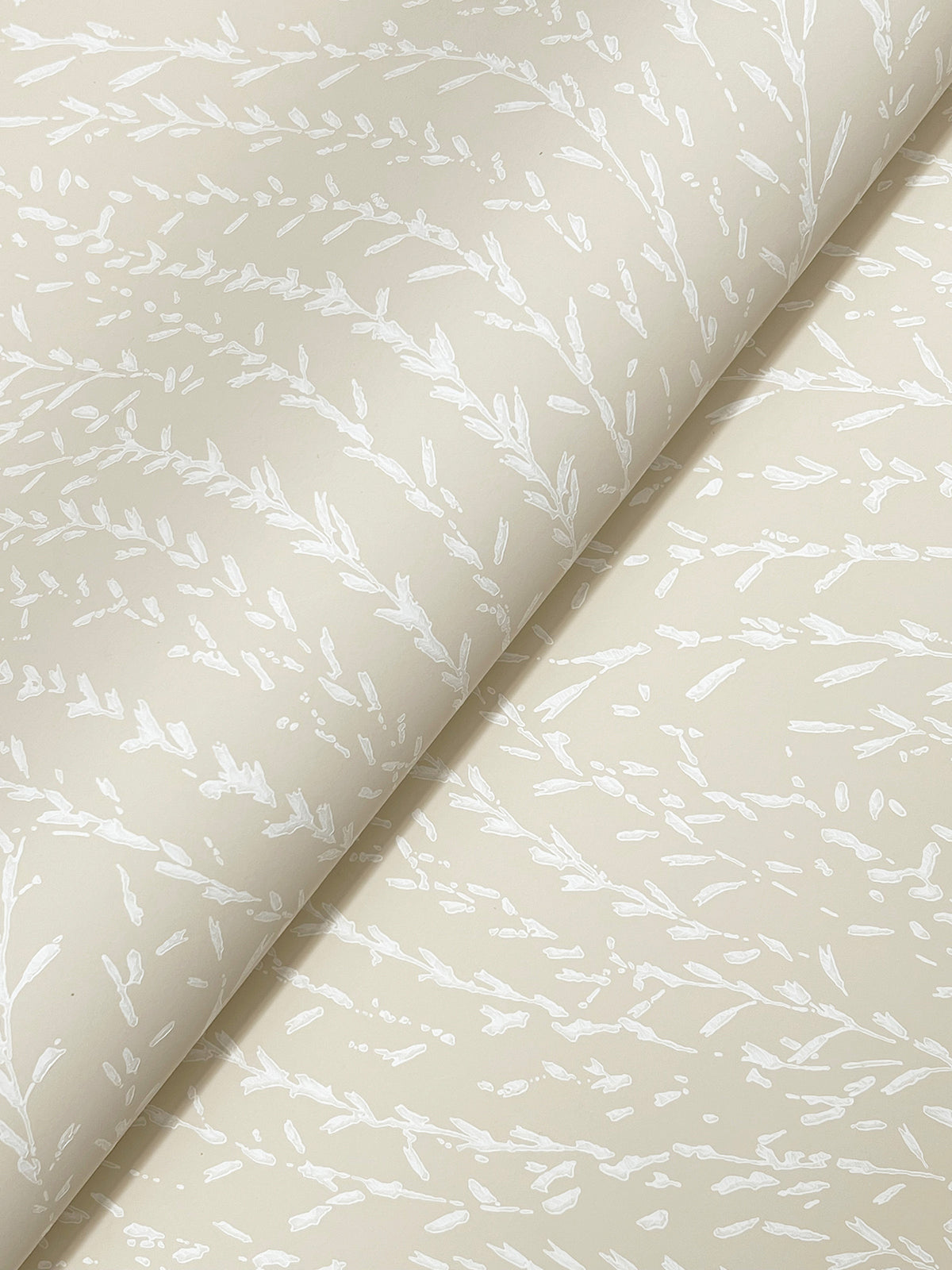 Transforming your sentence with the provided product data: “York Wallcoverings’ Willow Song Botanical Wallpaper features a rolled beige backdrop adorned with a subtle, white leafy branch pattern spread diagonally across the surface, creating a gentle, organic design.”.