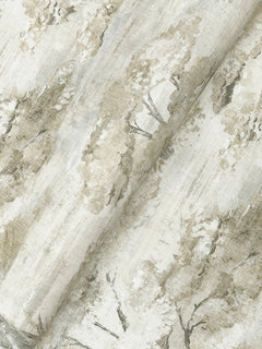 York Wallcoverings’ Moreno Woodland Wallpaper features a painterly, nature-inspired pattern of trees and foliage in soft beige and light brown tones. The wallpaper is shown with gentle folds, highlighting its texture and intricate design details.