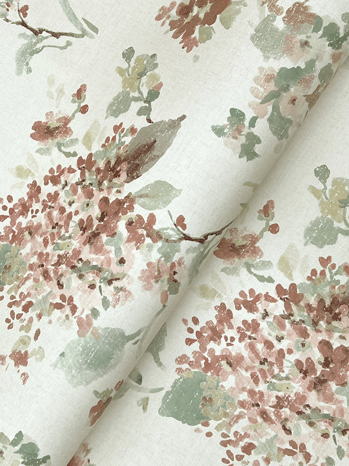 Veiled Garden Floral Wallpaper by York Wallcoverings features clusters of small flowers and leaves in muted pink, green, and brown tones on a pale background, creating a soft, vintage-inspired look.