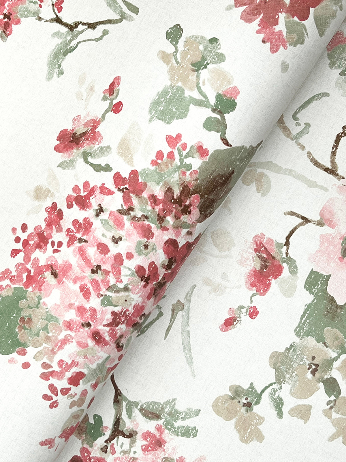 Veiled Garden Floral Wallpaper by York Wallcoverings features watercolor-like pink, red, green, and beige flowers and leaves on a white background, shown slightly folded.