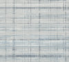 Vanishing Point Striated Wallpaper by York Wallcoverings features an abstract pattern of horizontal and vertical gray and blue lines on a light background, evoking the look of textured, woven fabric or a watercolor grid design.