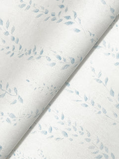 A close-up of York Wallcoverings’ Alpenrose Vine Wallpaper showcases its light-colored design featuring a subtle, pale blue leaf pattern with a gentle diagonal fold running through the center.