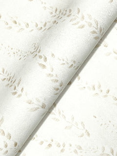 Close-up of the Alpenrose Vine Wallpaper by York Wallcoverings, featuring a white textured surface with a subtle beige leaf pattern in a diagonal, repetitive design; one section is gently folded over itself.
