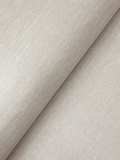 A close-up of York Wallcoverings’ Hempfield Weave Loomed Wallpaper in a light beige shade showcases its subtle, textured pattern. The wallpaper is displayed with a diagonal fold, highlighting the fine horizontal and vertical threads that create its woven look. The surface appears smooth with a gentle sheen.