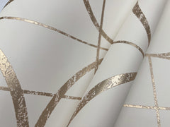 Close-up of Sun Circles Wallpaper by York Wallcoverings, featuring cream-colored paper with metallic gold geometric lines and curves that create a modern abstract pattern. The slightly textured, reflective gold lines add dimension to the design.