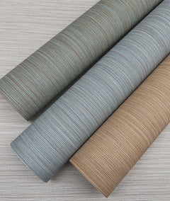 Three rolls of Cannete Wallpaper by York Wallcoverings, featuring blue, teal, and tan shades with fine horizontal lines, are displayed on a light gray, similarly textured surface.