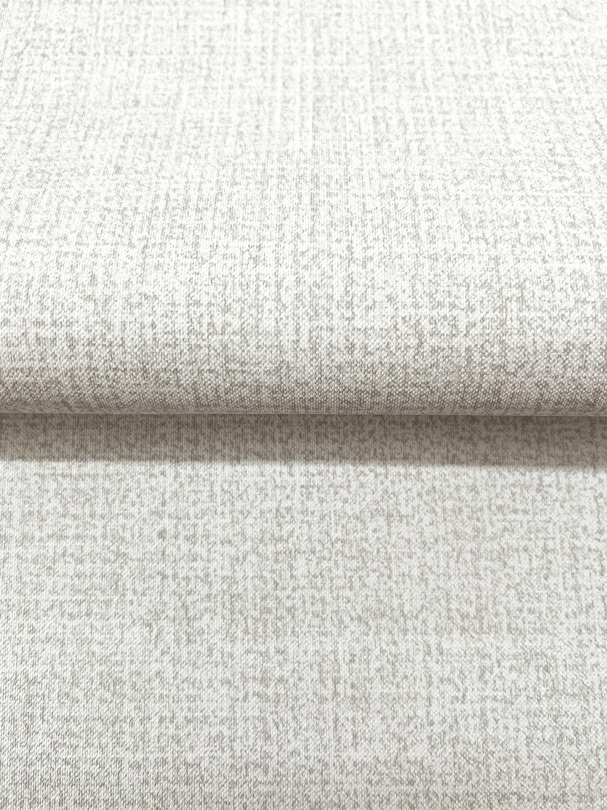 A roll of Magnolia Home Brindled Wallpaper in a neutral tone with a subtle, fine-grained textured pattern.