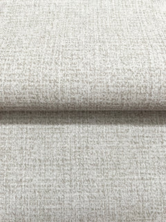 Close-up of a roll of Magnolia Home Brindled Wallpaper in tan with a mottled, textured pattern.