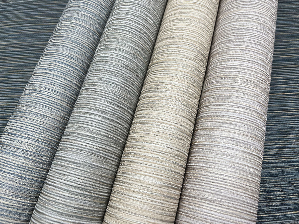Four rolls of Grass Roots Wallpaper featuring a horizontal linear texture in various shades of blue, gray, and beige.