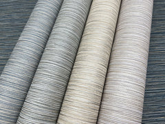 Four rolls of Grass Roots Wallpaper featuring a horizontal linear texture in various shades of blue, gray, and beige.
