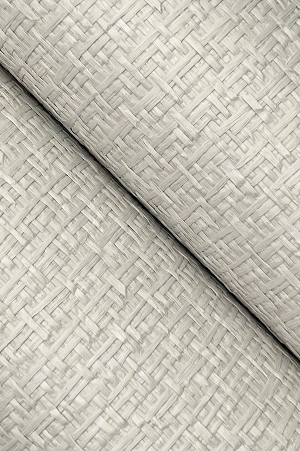 Close-up of two layers of York Wallcoverings’ Ronald Redding Tatami Weave Wallpaper in beige, featuring a textured basket-weave pattern, arranged diagonally and overlapping each other.