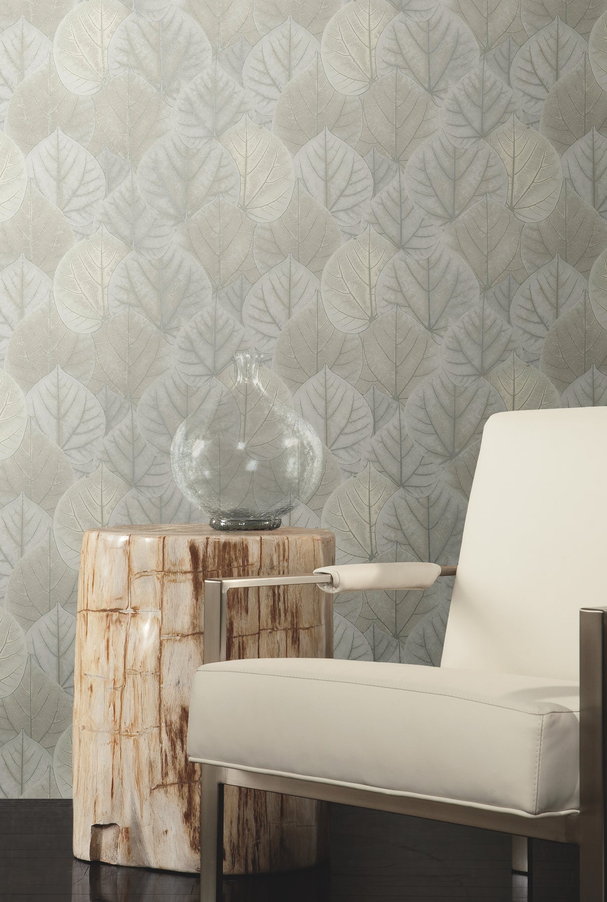 Candice Olson Leaf Concerto Wallpaper featuring a repeating pattern of pale, overlapping leaves behind a wooden side table and a modern armchair.