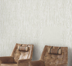 Two tan tufted leather armchairs with headrest pillows positioned against Ronald Redding Heartwood Wallpaper.
