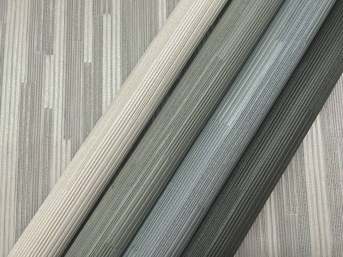 Four rolls of gray Ronald Redding Newel Wallpaper arranged diagonally across a matching patterned background.
