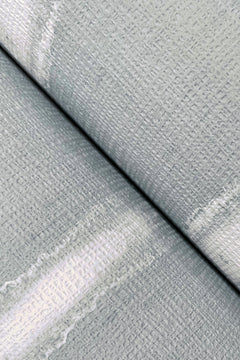 Close-up of two textured Resound Wallpaper surfaces by York Wallcoverings in light gray, overlapping at an angle. The visible weave patterns feature subtle white streaks and softly faded areas across the surface.