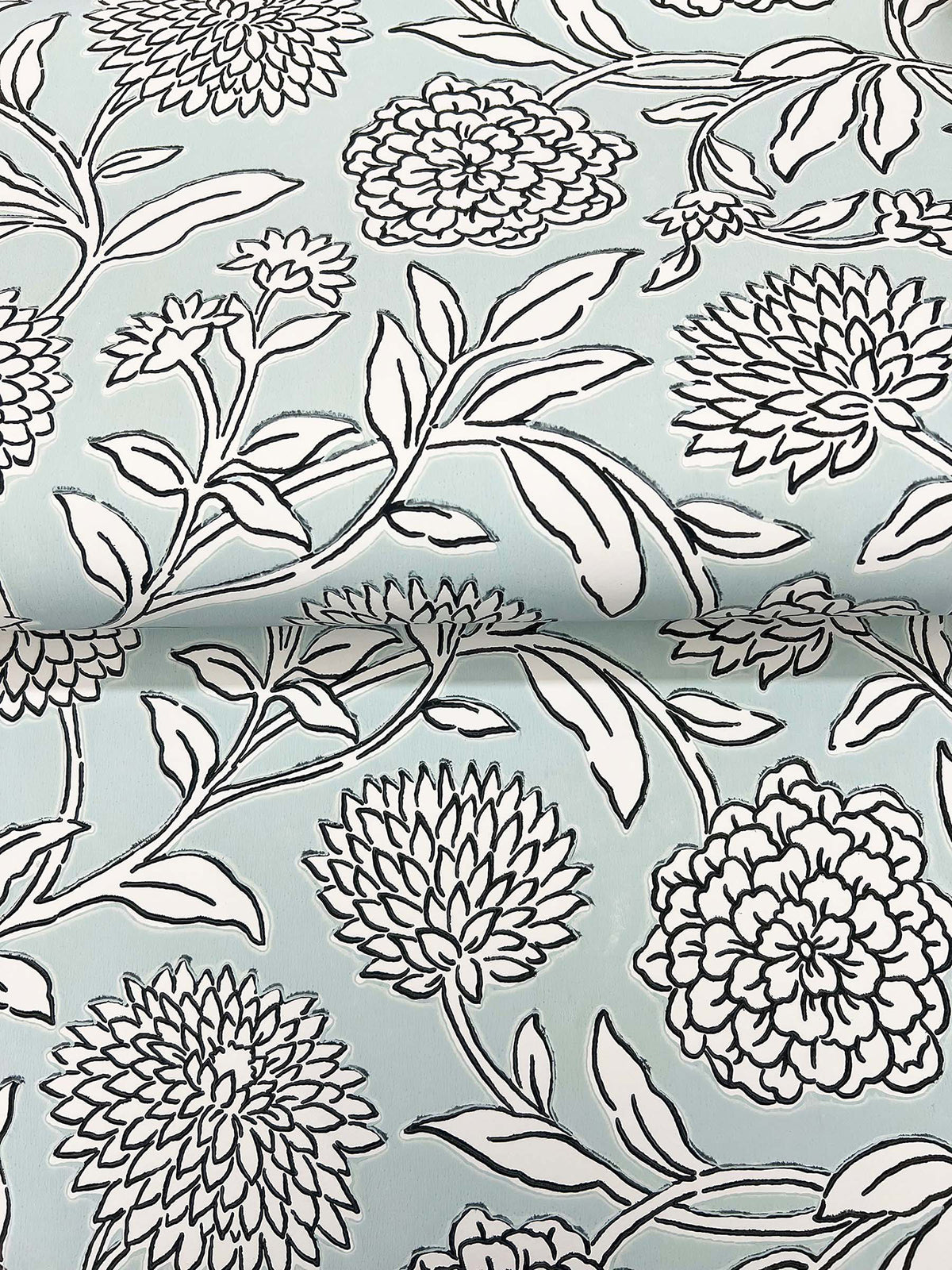 Chatsworth Garden Floral Trail Wallpaper by York Wallcoverings features a light blue background adorned with a white and black outlined botanical design of large, detailed blossoms and leafy branches, creating a bold and graphic floral motif.