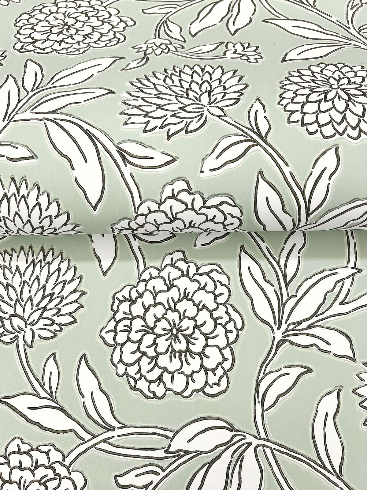 Chatsworth Garden Floral Trail Wallpaper by York Wallcoverings features a light green background with a bold black and white floral pattern of large blooming flowers and leaves. The striking design is characterized by thick outlines and repeats seamlessly across the surface.