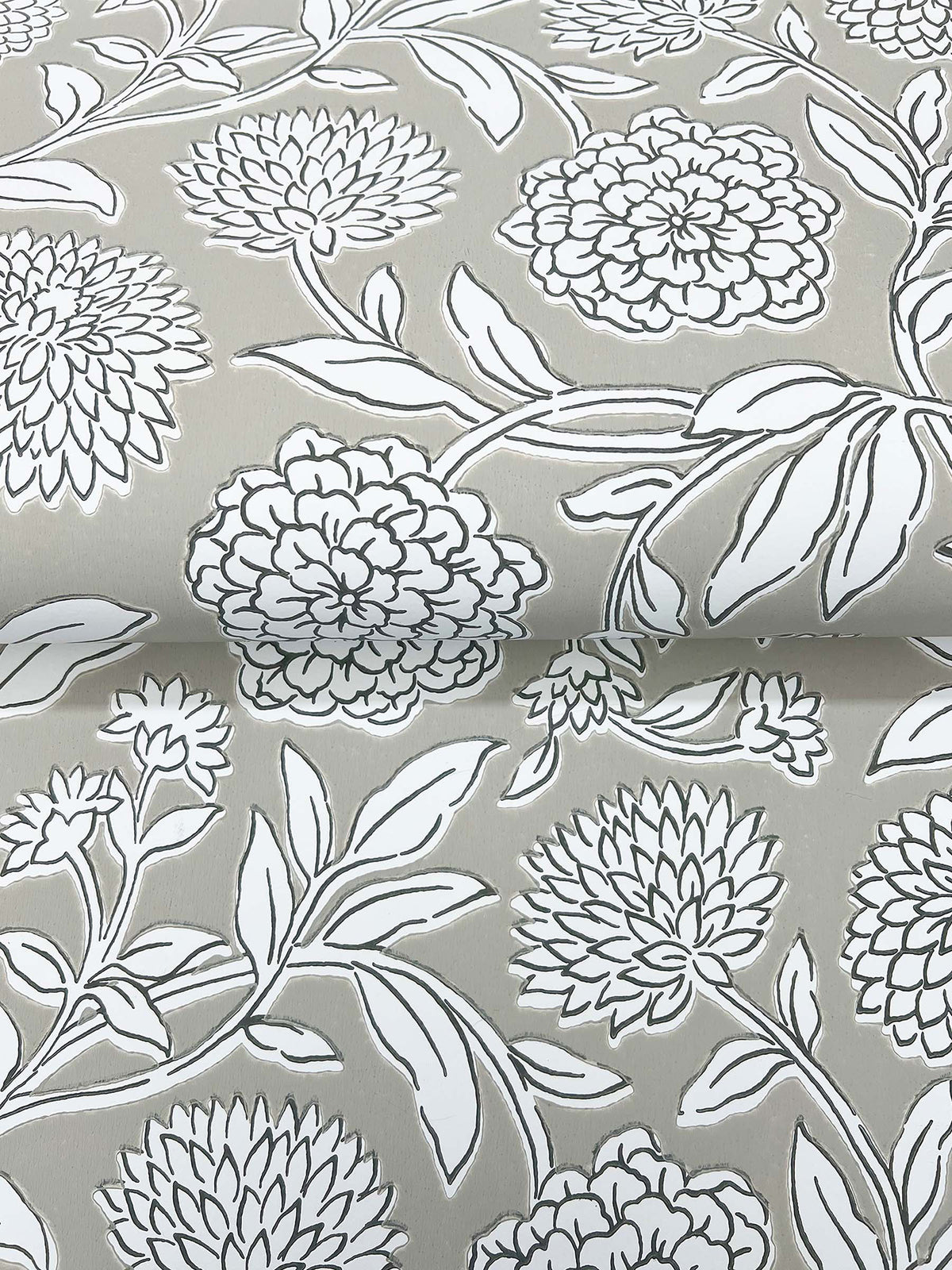 Chatsworth Garden Floral Trail Wallpaper by York Wallcoverings features a gray background adorned with a white floral pattern of large blooming flowers and intricately outlined leaves. The detailed design repeats across the surface, creating a gentle sense of depth with subtle folds and overlapping elements.