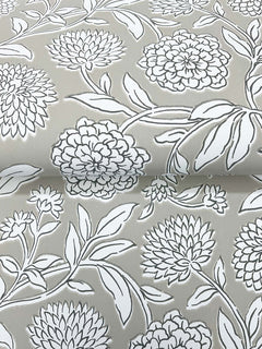 Chatsworth Garden Floral Trail Wallpaper by York Wallcoverings features a gray background adorned with a white floral pattern of large blooming flowers and intricately outlined leaves. The detailed design repeats across the surface, creating a gentle sense of depth with subtle folds and overlapping elements.