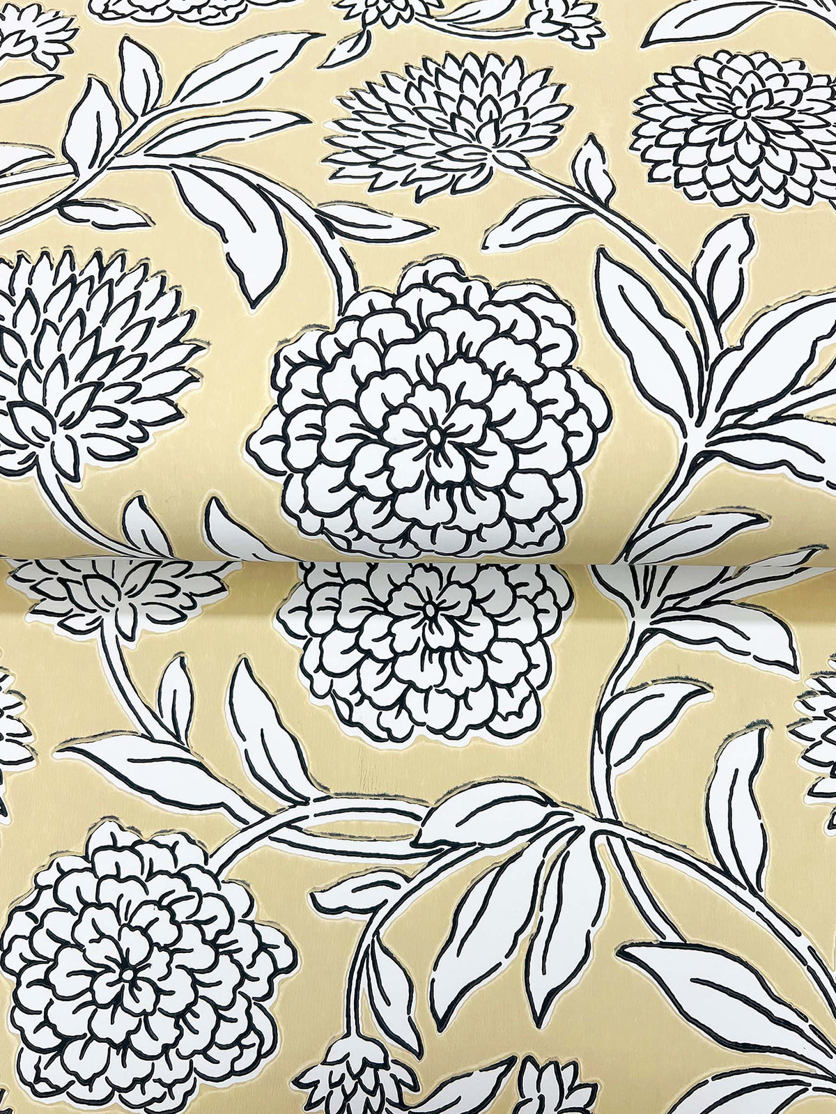 Chatsworth Garden Floral Trail Wallpaper by York Wallcoverings features a yellow background adorned with a black-and-white floral design of large, detailed flowers and leaves. The repeating pattern is visible on the partially unrolled wallpaper.