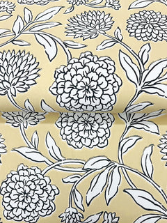 Chatsworth Garden Floral Trail Wallpaper by York Wallcoverings features a yellow background adorned with a black-and-white floral design of large, detailed flowers and leaves. The repeating pattern is visible on the partially unrolled wallpaper.