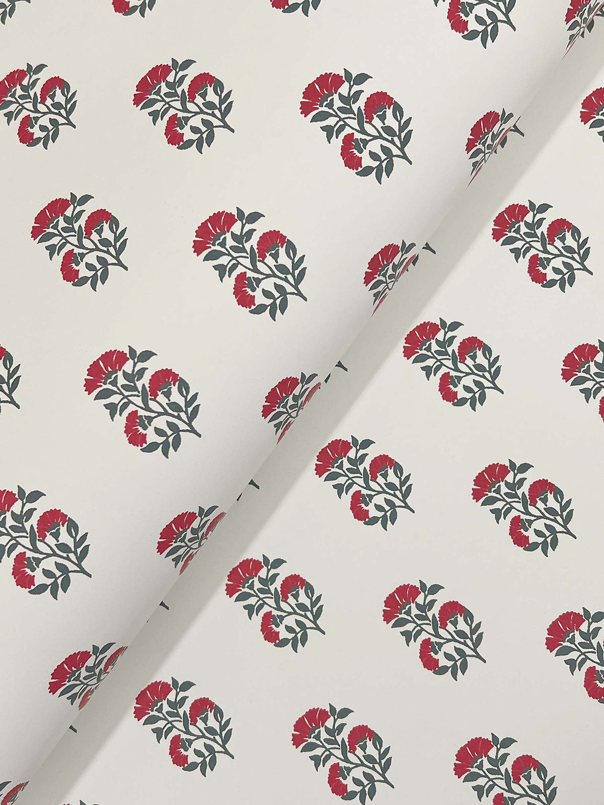 Sylvie Floral Wallpaper by York Wallcoverings features a white background adorned with small clusters of red flowers and green leaves, arranged in evenly spaced rows, with the wallpaper shown partially folded at an angle across the image.