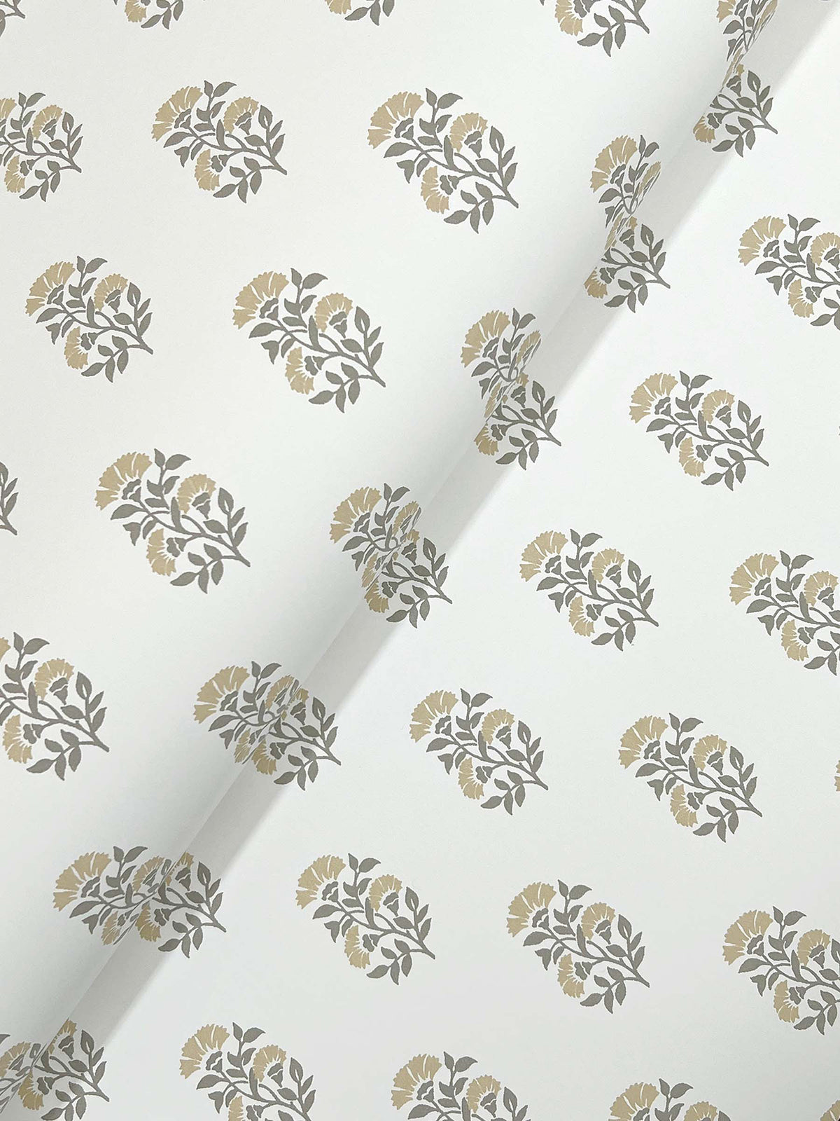 Sylvie Floral Wallpaper by York Wallcoverings features a white background adorned with a repeating pattern of grey leaves and muted yellow flowers; the wallpaper is shown with a visible diagonal crease across the center.