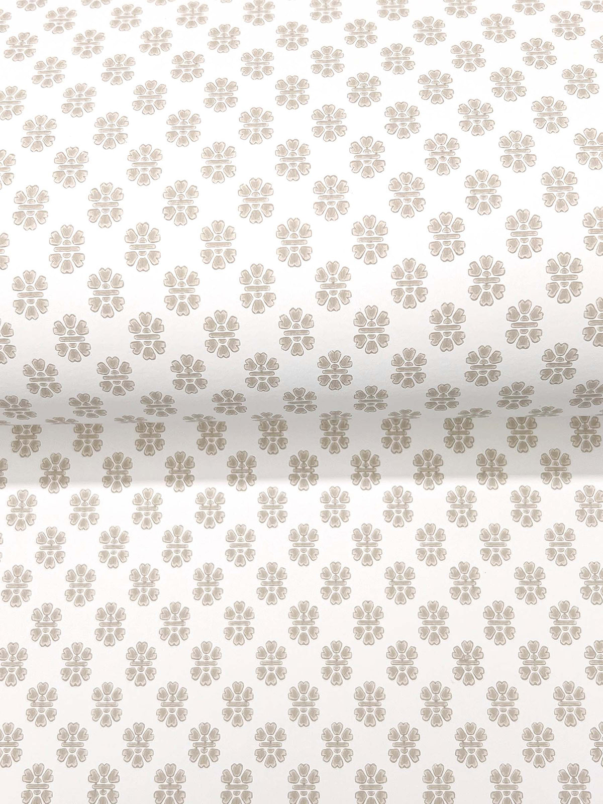 Brioni Floral Stamp Wallpaper by York Wallcoverings features a rolled white wallpaper adorned with a repeating pattern of small, light brown four-petal flowers evenly spaced across the surface.
