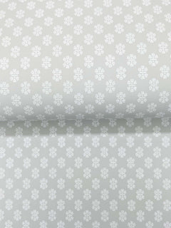 Brioni Floral Stamp Wallpaper by York Wallcoverings features a light gray background adorned with a repeating pattern of small, white, four-petaled flowers evenly spaced across the surface. The simple and subtle design creates a soft, elegant look.
