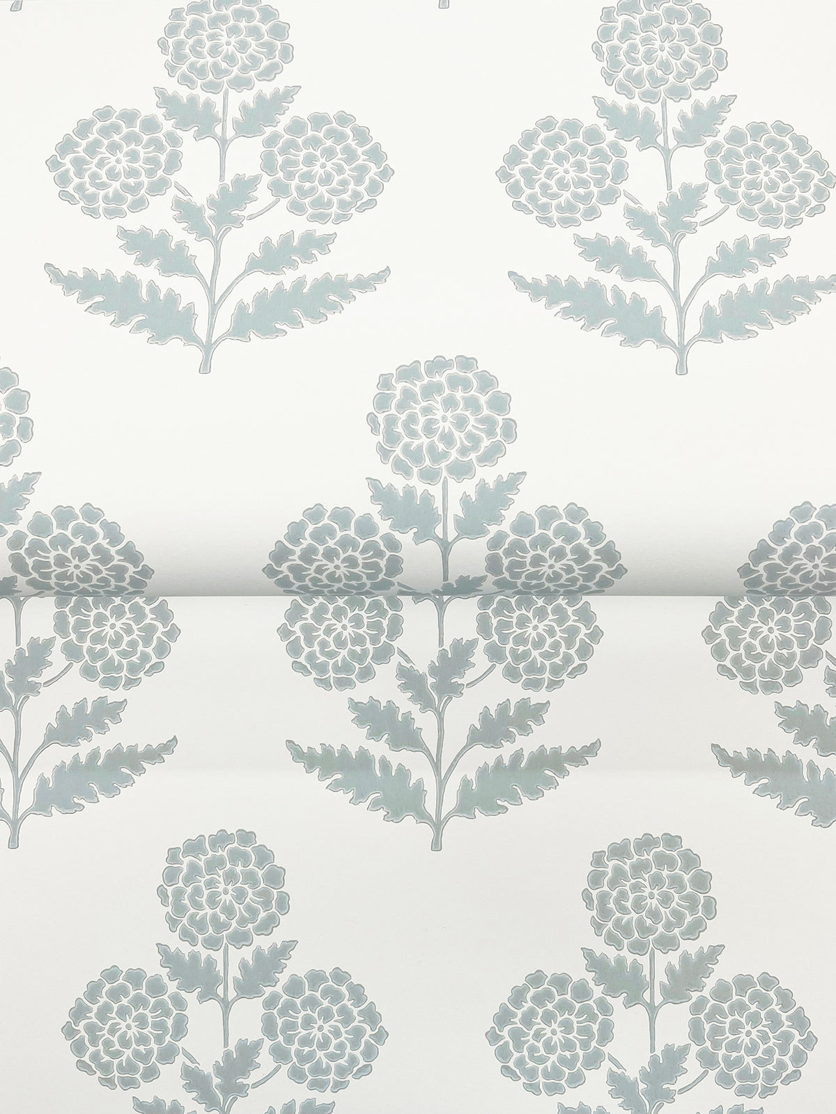 The Souci Marigolds Wallpaper by York Wallcoverings features a repeating pattern of light blue floral designs with leaves on a white background, with the flowers evenly spaced and aligned in horizontal rows.