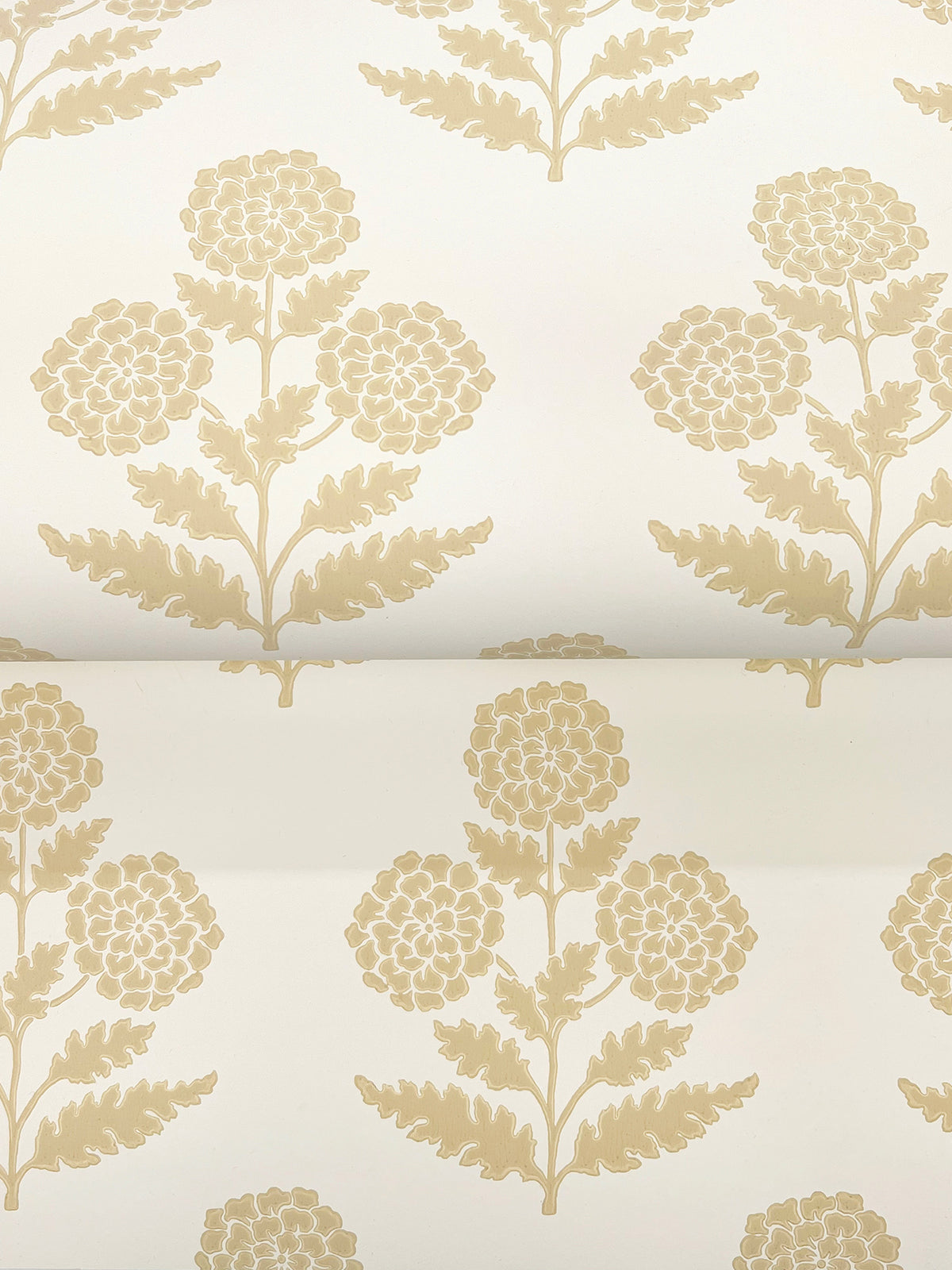 The Souci Marigolds Wallpaper by York Wallcoverings features a cream-colored background adorned with a repeating pattern of stylized gold floral motifs, each showcasing clusters of round flowers and detailed leaves arranged in precise horizontal and vertical rows.