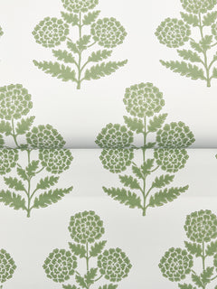 Souci Marigolds Wallpaper by York Wallcoverings features a green floral pattern with stylized marigold flowers, each displaying round clusters of petals and leafy stems, all arranged in a repeating, symmetrical design on a white background. The wallpaper is shown partially rolled out.